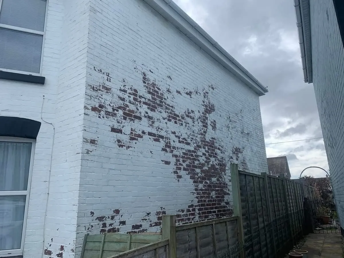 Peeling paint on a brick wall before redecoration in Padstow